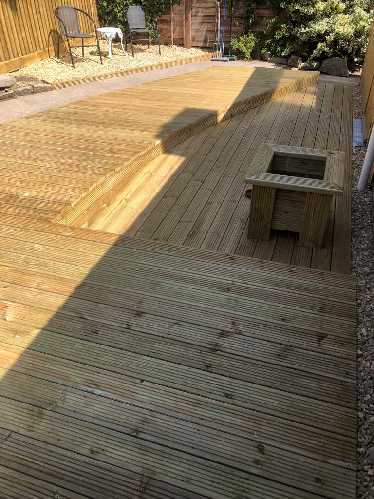 Custom made, curved decking with wooden planter.