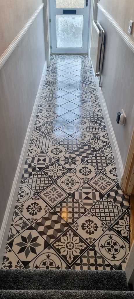 A black and white tiled floor in a hallway.
